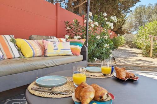 une table avec deux assiettes de nourriture et deux verres de jus d'orange dans l'établissement Casa Albera N1 des Villages préférés des Français, à Collioure