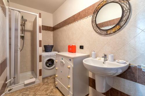 a bathroom with a sink and a washing machine at Casa Vacanze vicino ad alghero in Olmedo