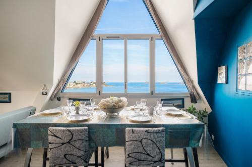 une salle à manger avec une table et une grande fenêtre dans l'établissement Casa del mar, à Dinard