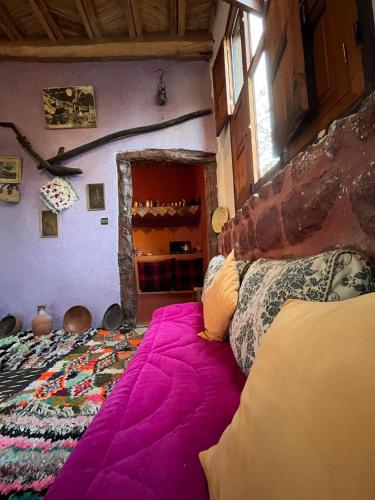 a bedroom with a bed with a purple blanket at Villa Djana Ouirgane in Ouirgane