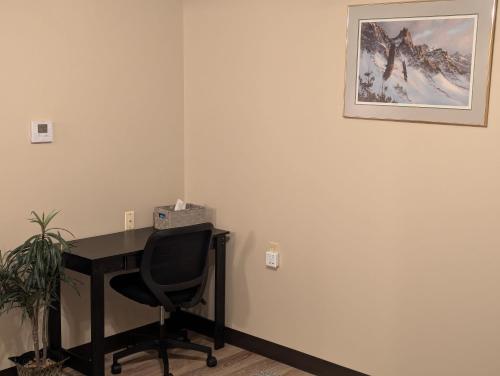 a desk with a chair and a picture on the wall at Waterloo Suites Double in Waterloo