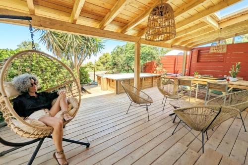 une femme assise dans un fauteuil roulant sur une terrasse couverte dans l'établissement L'Évasion Naturelle N1 des Villages des Français, à Argelès-sur-Mer