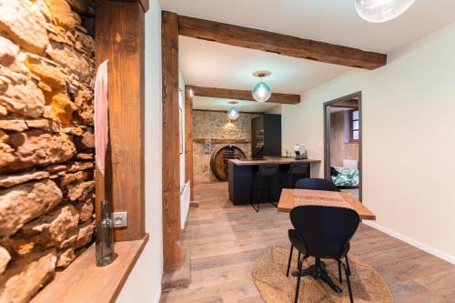 Cette chambre dispose d'un mur en pierre, de deux chaises et d'une table. dans l'établissement Zellenberg - Les Amandiers - Spa & Sauna, à Zellenberg