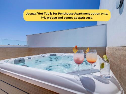 two wine glasses sitting in a hot tub at Bayside A Apartments in St Julian's