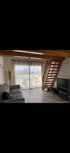a living room with a couch and a large window at Appartement Oriana in Montegrosso