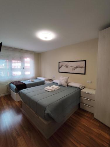 a bedroom with two beds in a room at Piso recién reformado en Gascona in Oviedo