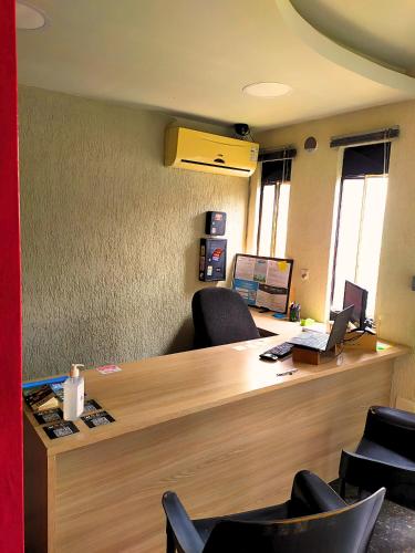 an office with a desk with chairs and a laptop at MEC Office Hostel in Niterói