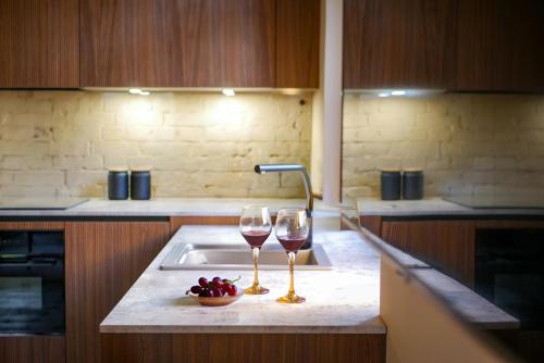two glasses of wine sitting on a kitchen sink at ARVED Apartments in Lübeck