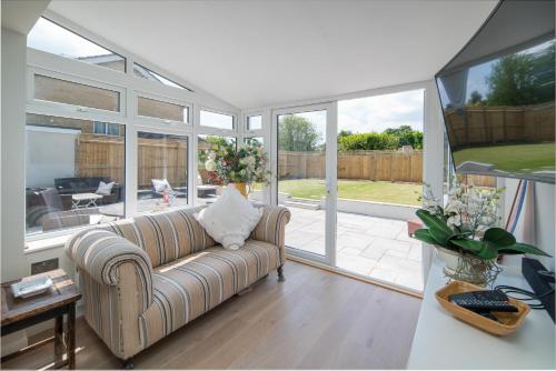a living room with a couch and sliding glass doors at Meadow Drive in Bembridge