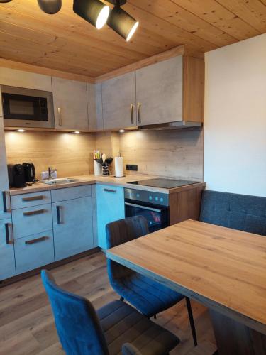 a kitchen with a wooden table and blue cabinets at Ferienwohnung Filomena im Hotel Casada in Galtür