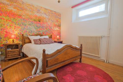 a bedroom with a large painting on the wall at Gite cosy De Monplaisir in Périgueux