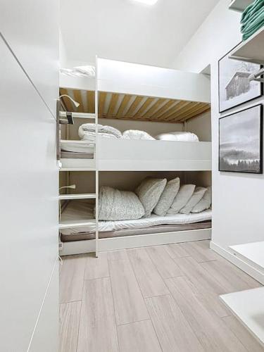 Cette chambre dispose d'étagères blanches et d'oreillers blancs. dans l'établissement Beau studio 5 places à Auron - plein coeur station, à Saint-Étienne-de-Tinée