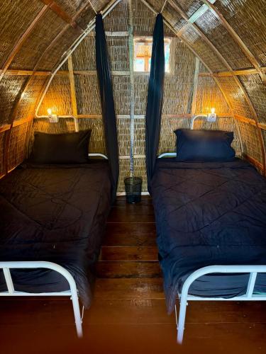 two beds in a yurt with a hammock in it at Rafikis Retreat in Koh Rong Island