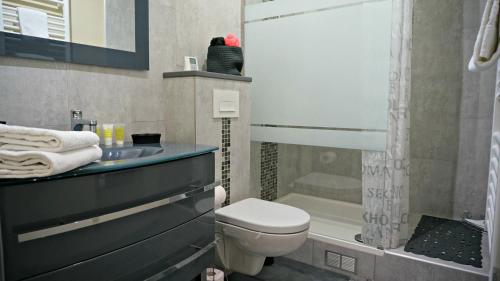 une salle de bain avec toilettes, lavabo et douche dans l'établissement Little Suite - Nathan, à Lille