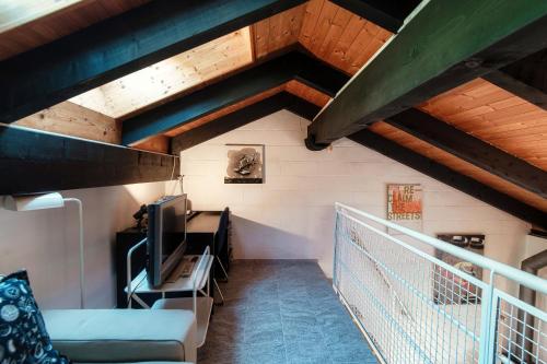 a room with a staircase with a couch and a tv at Casa Boschetto by Quokka 360 - silent oasis in Bosco Luganese in Bioggio