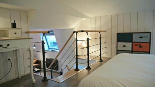 Cette chambre comprend un lit et un escalier. dans l'établissement Little Suite - Nathan, à Lille