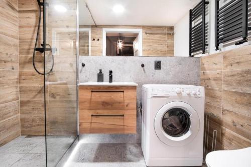 a bathroom with a washing machine and a shower at Revolution Aparts - Rewolucji 27 in Łódź