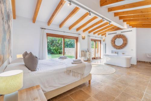 ein großes Schlafzimmer mit einem großen Bett und einem Badezimmer in der Unterkunft Cal Rei Gran in Pollença