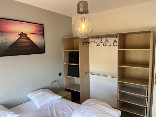 une chambre avec deux lits et une étagère dans l'établissement La fossette, au Lavandou