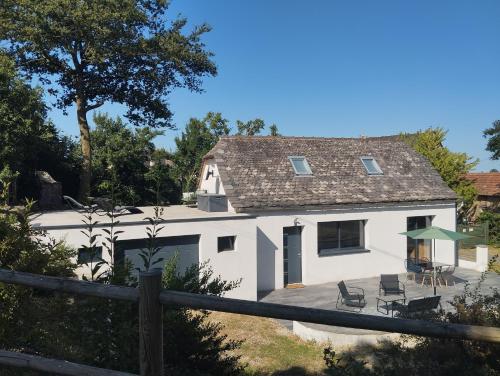 una casa blanca con una mesa y sillas en Gîte de charme L' Écrin Vert Aveyron, en Anglars-Saint-Félix