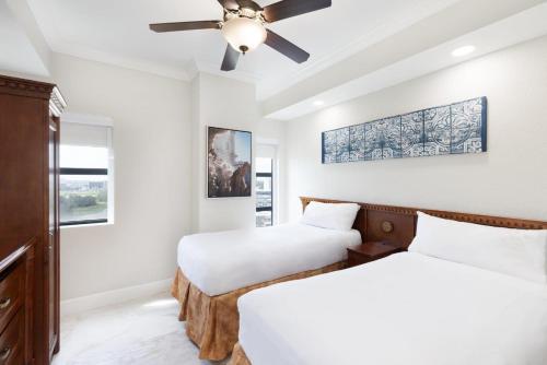 two beds in a room with a ceiling fan at Westgate Palace Hotel - Universal - I-Drive in Orlando