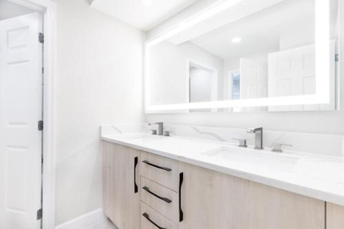 a white bathroom with two sinks and a mirror at Westgate Palace Hotel - Universal - I-Drive in Orlando