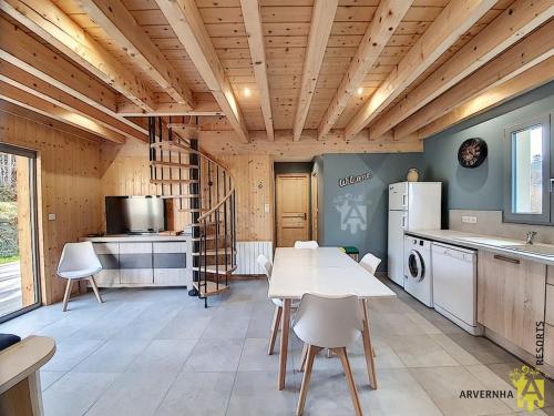 une cuisine avec une table et un réfrigérateur blanc dans l'établissement Chalet Caranne, à Besse-et-Saint-Anastaise