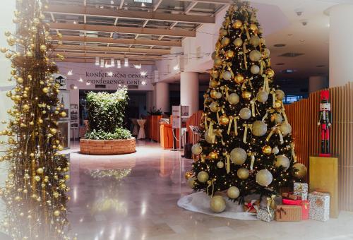 dos árboles de Navidad en un centro comercial con adornos navideños en City Hotel Ljubljana, en Liubliana