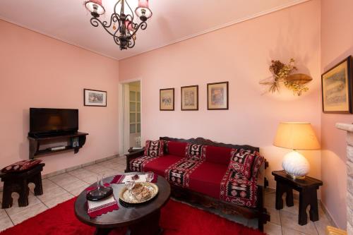 a living room with a red couch and a tv at Amygdalies Apartments with Fireplace in Karpenision