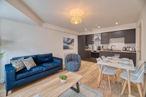 a living room with a blue couch and a table at Alexandra House by Guestz in Stockport