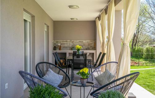 a porch with chairs and a table with flowers on it at Gorgeous Home In Radeki Glavica in Loborika