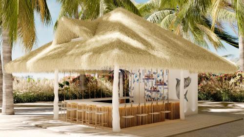 a gazebo with a straw roof on a beach at Dreams Playa Esmeralda Resort & Spa - All Inclusive in Miches