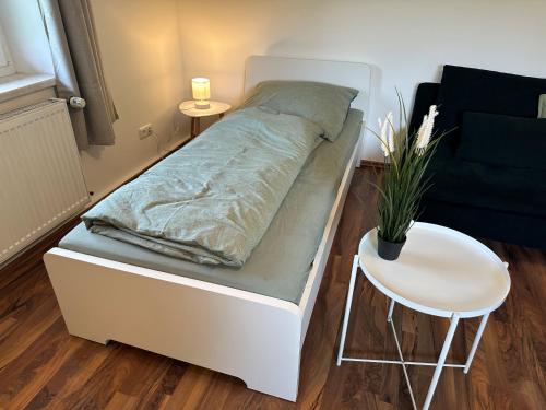 a bed in a room with a table and a chair at Ferienwohnungen Bahnhof Marxgrün in Naila