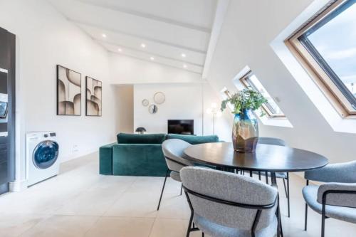 - un salon avec un canapé vert, une table et des chaises dans l'établissement Sweett - Boccador A, à Paris