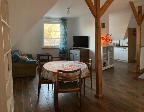 a living room with a table and a kitchen at Agroturystyka u Sylwii in Majdan Sopocki