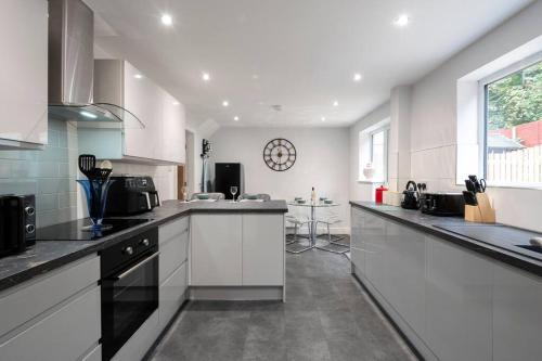 a large kitchen with white cabinets and a window at Brumby 3-Bed House by Brookland Stays Serviced Accommodation with WiFi in Brumby