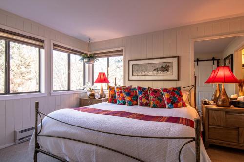 a bedroom with a bed and two lamps and windows at Cottonwood Condo 1469 in Sun Valley