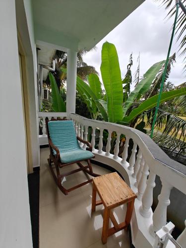 a balcony with a blue chair and a wooden table at SOLS Backyard in Arambol