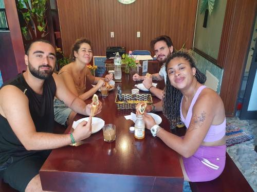 een groep mensen die aan een tafel zitten en eten bij Villa De Pi's Hoi An in Hội An