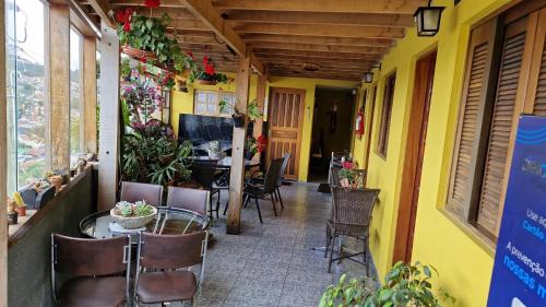 a patio with chairs and a table in a building at Suites Bella vista in Campos do Jordão