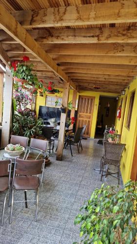 a patio with chairs and tables and a wooden ceiling at Suites Bella vista in Campos do Jordão
