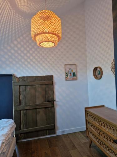 a bedroom with a bed and a chandelier at Gîte des Lavandières in Amanlis