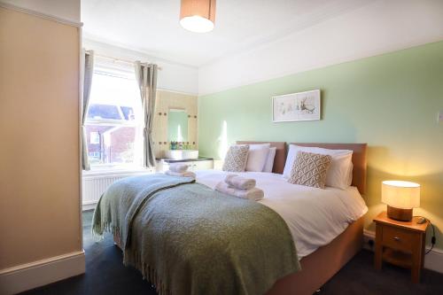 a bedroom with a bed with white sheets and a window at The Albany Rooms Bexhill in Bexhill
