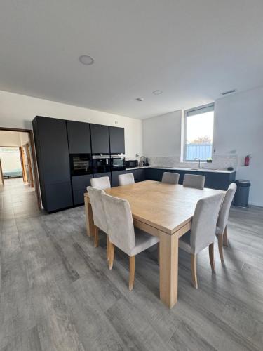 une salle à manger avec une table et des chaises en bois dans l'établissement Loft épuré avec parking privé., à Saint-Symphorien-dʼOzon