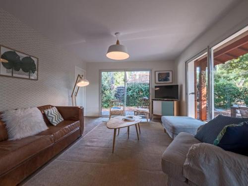 un salon avec un canapé et une table dans l'établissement Villa Les Violettes à deux pas de la plage PYLA SUR MER, à La Teste-de-Buch