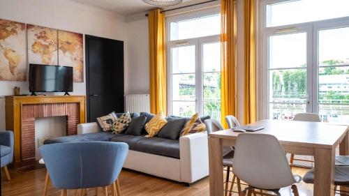 un salon avec un canapé et une table dans l'établissement L'Escale - Grand appartement 4 chambres, à Poitiers