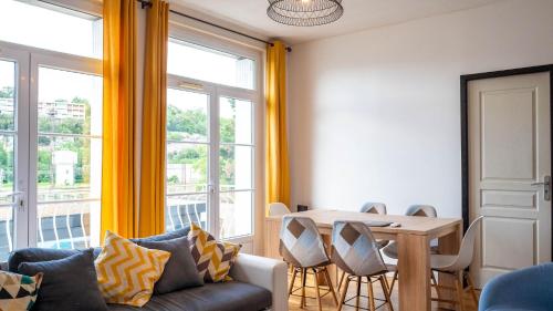 un salon avec un canapé et une table avec des chaises dans l'établissement L'Escale - Grand appartement 4 chambres, à Poitiers