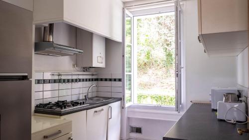une cuisine avec un évier et une fenêtre dans l'établissement L'Escale - Grand appartement 4 chambres, à Poitiers