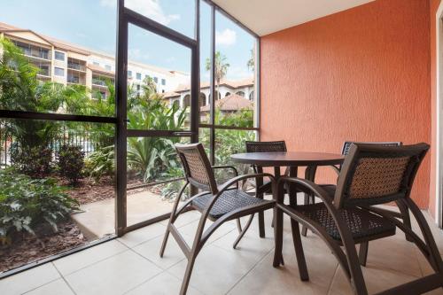 a patio with a table and chairs and a balcony at Westgate Lakes Resort and Spa in Orlando