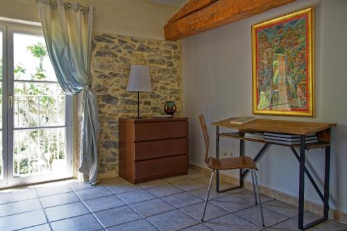 Cette chambre comprend un bureau, une table et une fenêtre. dans l'établissement Domaine de Curé, à Conques-sur-Orbiel